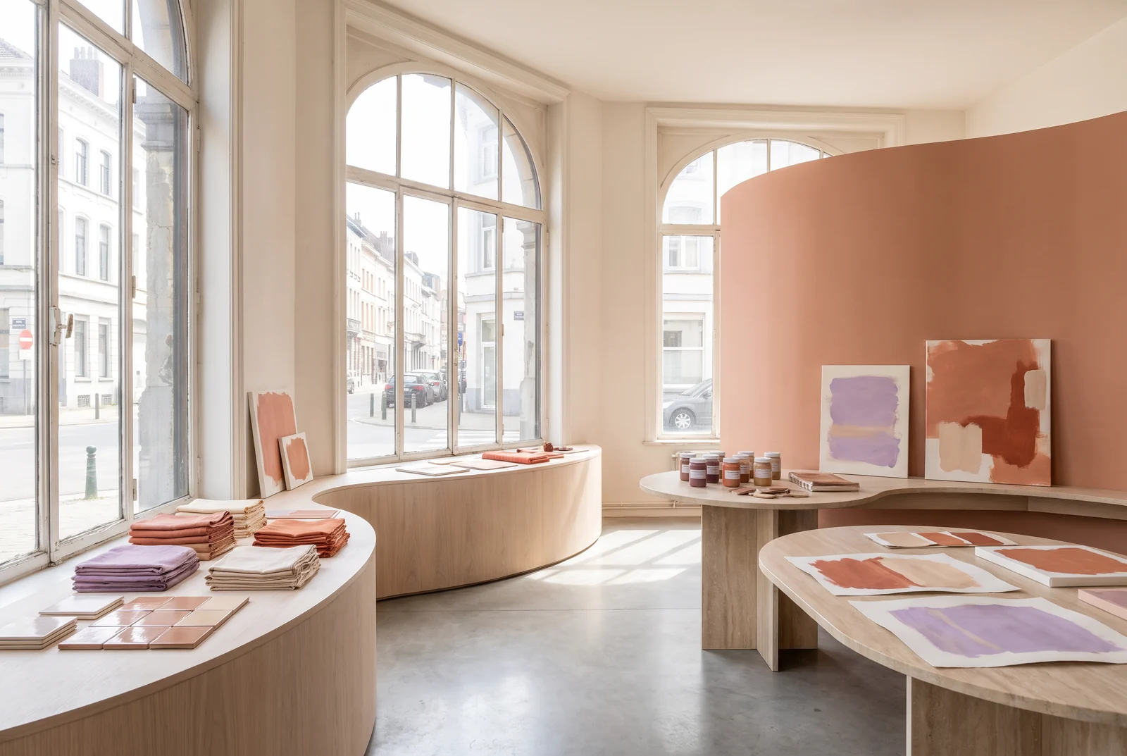 Lichte ruimte met terracotta kleurvlakken en gebogen presentatiemeubels