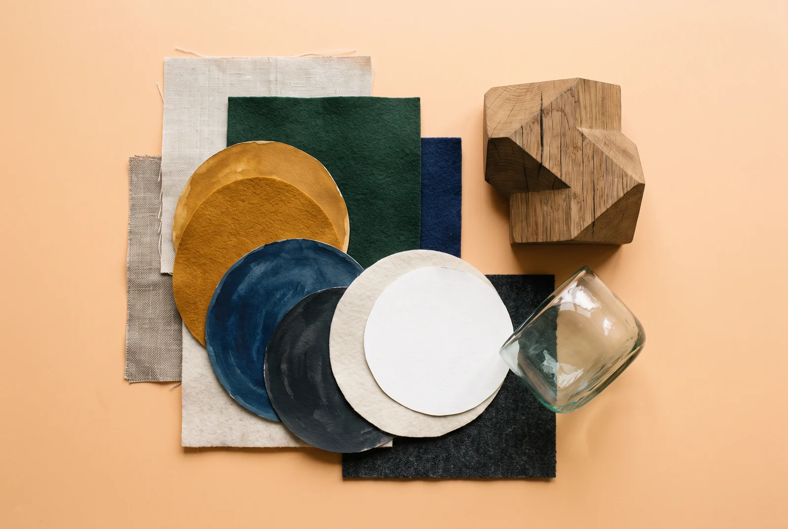 Compositie van gekleurde papier- en materiaalstalen op een perzikkleurige ondergrond